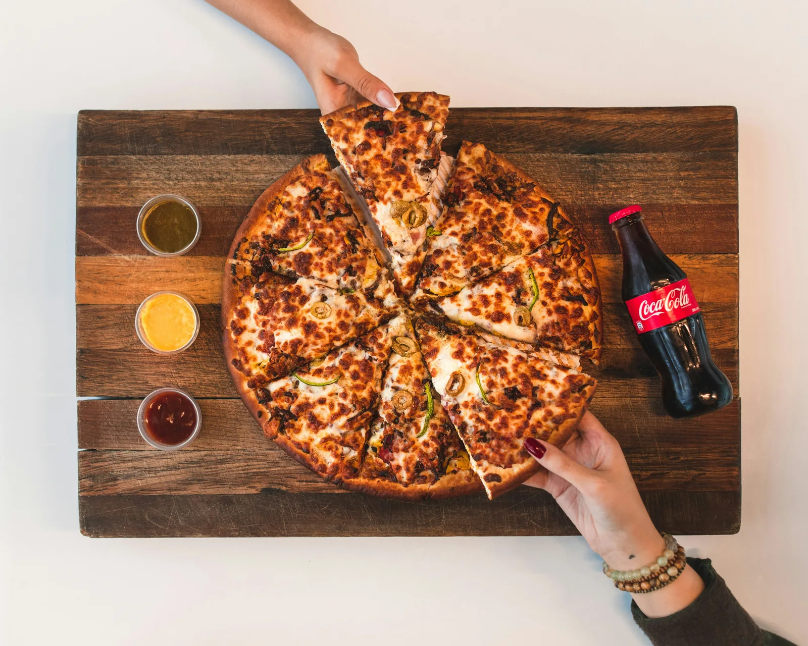 HearthStone Pizza WebP — a perfectly charred wood-fired pie resting on a black slate board under dramatic gold lighting
